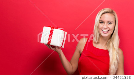 Young woman holding a Christmas gift 34451538
