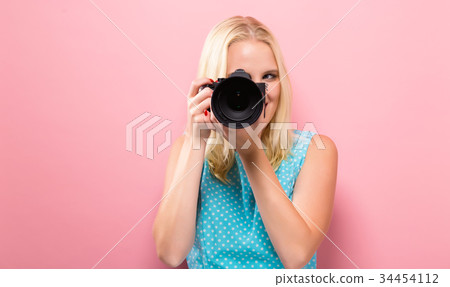 Young woman comparing professional camera Young woman comparing professional camera 34454112