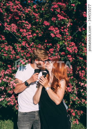 Couple in park eating ice cream cones Couple in park eating ice cream cones 34455077