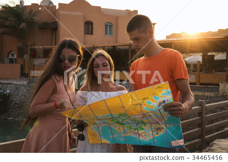 tourists with map reserch the city on sunset tourists with map reserch the city on sunset 34465456
