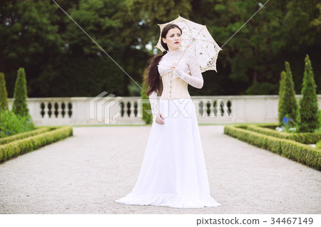 Woman in white Victorian dress with umbrella 34467149