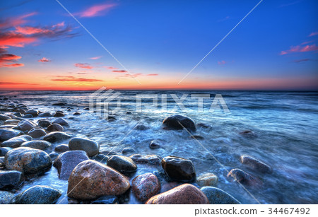Sunset over the Baltic sea. The pebbly beach Sunset over the Baltic sea. The pebbly beach 34467492