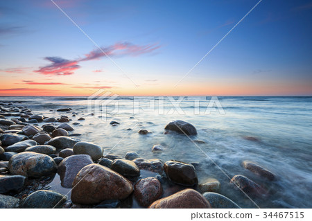 Sunset over the Baltic sea. The pebbly beach Sunset over the Baltic sea. The pebbly beach 34467515
