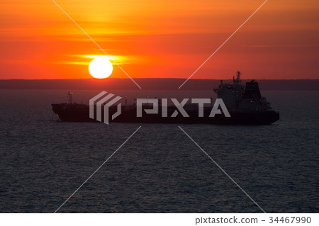Crago ship at anchor when it sunset. 34467990