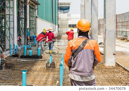 worker on boom pump pouring concrete on metal rod 34470076