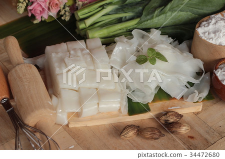 Making rice noodle flat on wood background. Making rice noodle flat on wood background. 34472680