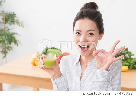 A woman drinking vegetable juice 34473758