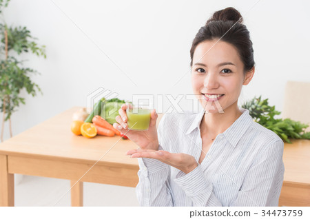 A woman drinking vegetable juice 34473759