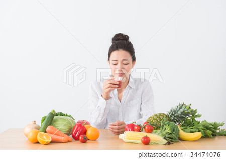 A woman drinking tomato juice 34474076