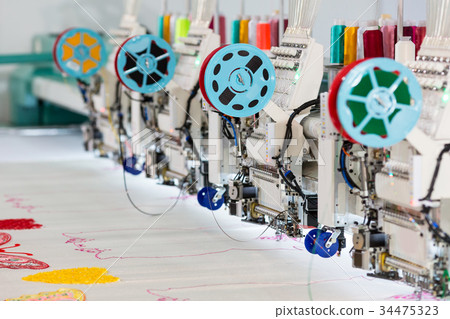 Factory sewing machine makes color pattern closeup 34475323