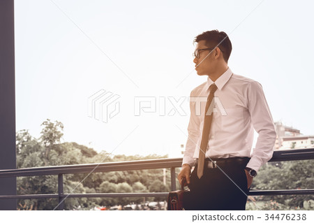 Worried businessman standing at office about work Worried businessman standing at office about work 34476238