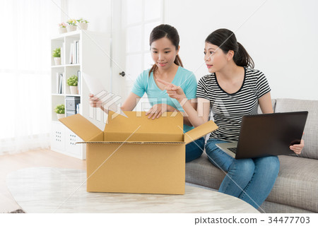 elegant women buyer opening shipping parcel 34477703