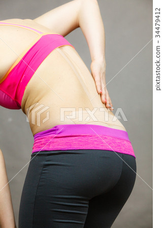 Woman with medical kinesio taping on back Woman with medical kinesio taping on back 34479412