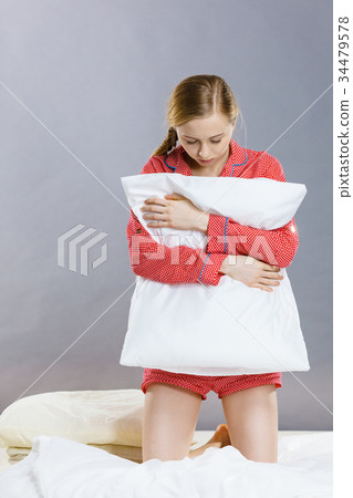 Sad depressed girl in bed gripping pillow 34479578