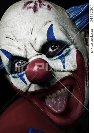 scary evil clown taking out his tongue 34482304
