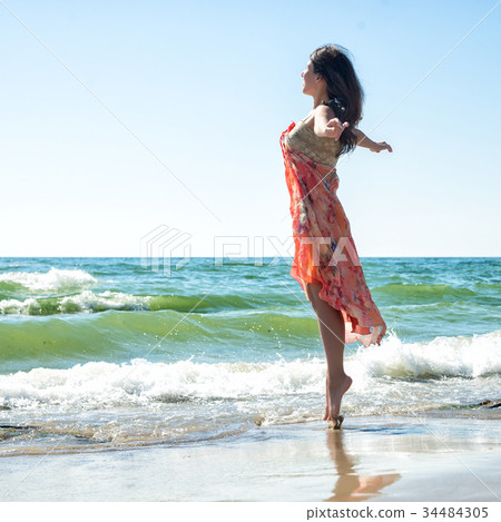 Young woman jumping on the beach Young woman jumping on the beach 34484305