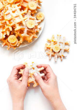 Woman hands holding the fresh homemade waffles Woman hands holding the fresh homemade waffles 34484781