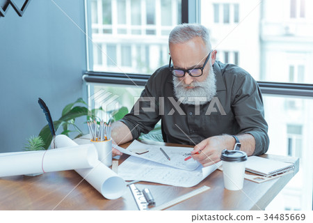 Focused old architect in glasses is laboring in Focused old architect in glasses is laboring in 34485669