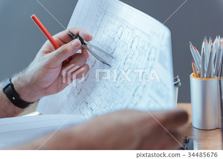 Architect is working with his building plan 34485676