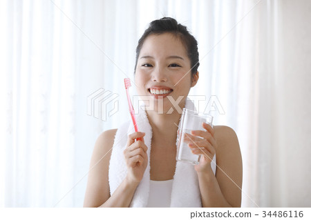 一個年輕女子刷牙 一個年輕女子刷牙 34486116