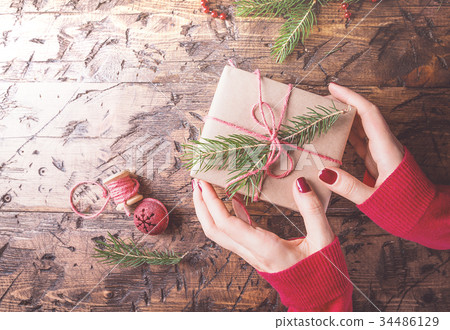 Woman's hands give christmas gift Woman's hands give christmas gift 34486129