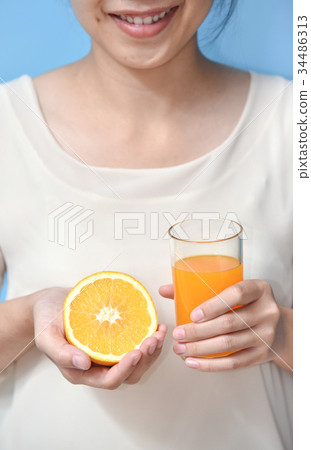 Woman holding sliced orange with Orange juice. Woman holding sliced orange with Orange juice. 34486313