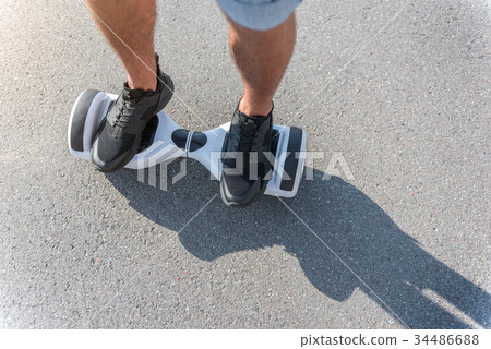 Male feet going on hoverboard at street 34486688