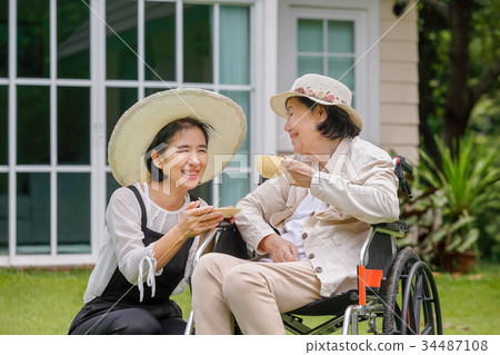 Elderly woman relax in backyard with daughter 34487108