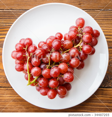 Red grape on wooden table 34487203