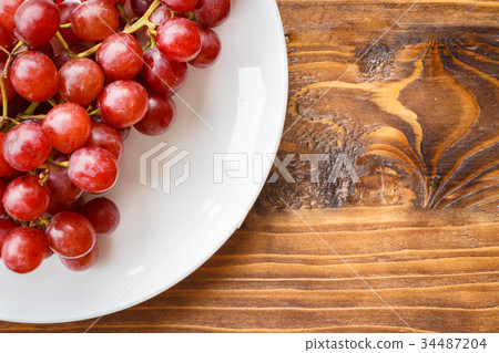 Red grape on wooden table Red grape on wooden table 34487204