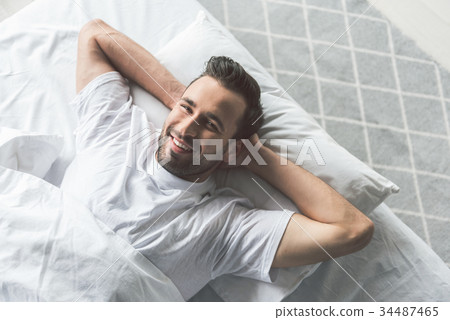 Cheerful guy waking up in the morning 34487465