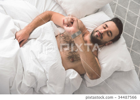 Happy guy checking time on wristwatch in the Happy guy checking time on wristwatch in the 34487566