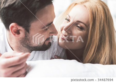 Joyful loving couple relaxing in bedroom Joyful loving couple relaxing in bedroom 34487694