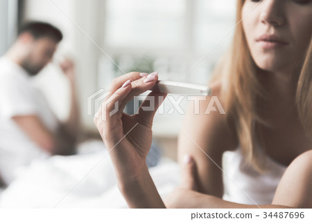 Thoughtful girl undergoing pregnancy test near Thoughtful girl undergoing pregnancy test near 34487696