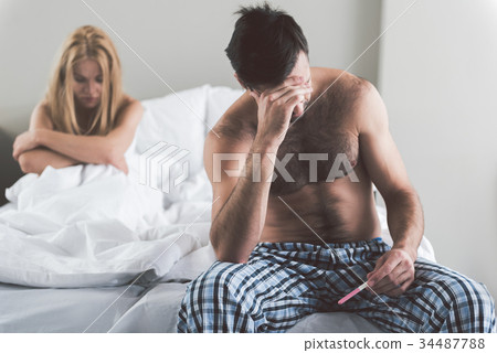 Despaired couple checking results of pregnant test Despaired couple checking results of pregnant test 34487788