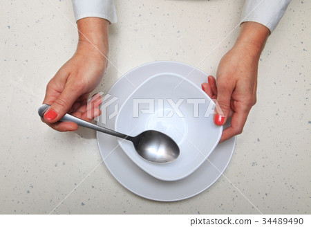 woman holds spoon and plate woman holds spoon and plate 34489490