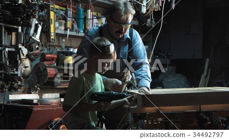 Carpenter with grandson making window 34492797