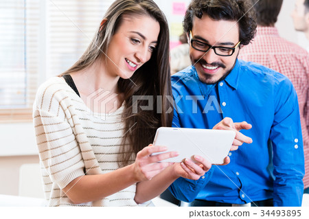 Young business people looking at tablet PC Young business people looking at tablet PC 34493895