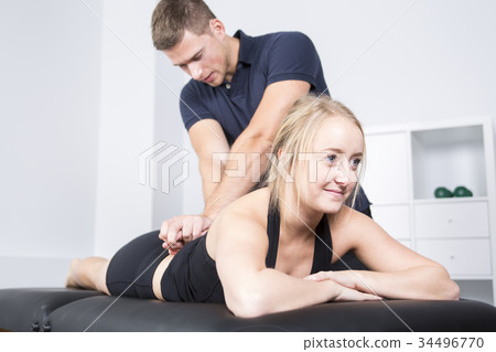 male physio therapist and woman helping patient 34496770