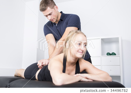 male physio therapist and woman helping patient 34496782