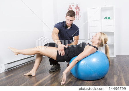 male physio therapist and woman helping patient 34496799