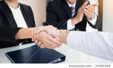 successful business team shaking hands with eachother in the off 34497409