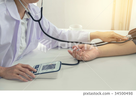 Competent attentive doctor being measuring blood pressure to pat Competent attentive doctor being measuring blood pressure to pat 34500498