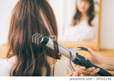Hairdresser hands wrapping hair with trowel 34502246