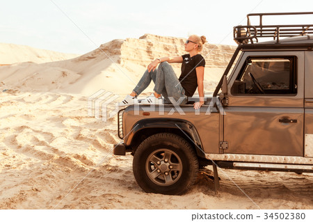 Woman is on the hood of the car. Woman is on the hood of the car. 34502380