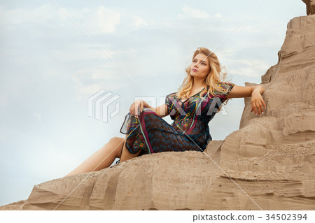 Woman is high on a sand dune. Woman is high on a sand dune. 34502394