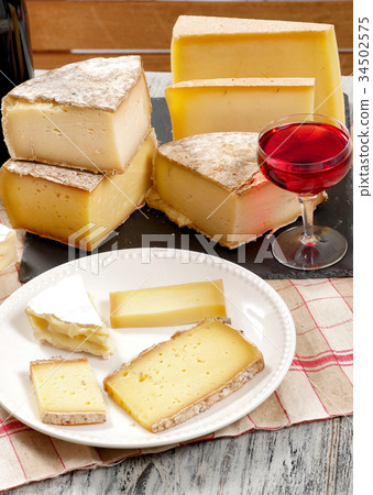 Different french cheeses with a glass of wine 34502575