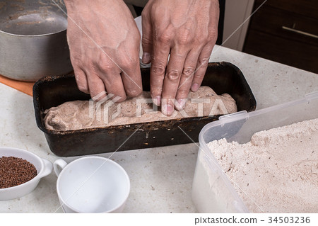 Man preparing bread dough on wooden table. 34503236