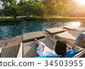 short hair young woman is resting at the pool bed 34503955