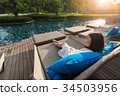 short hair young woman is resting at the pool bed 34503956
